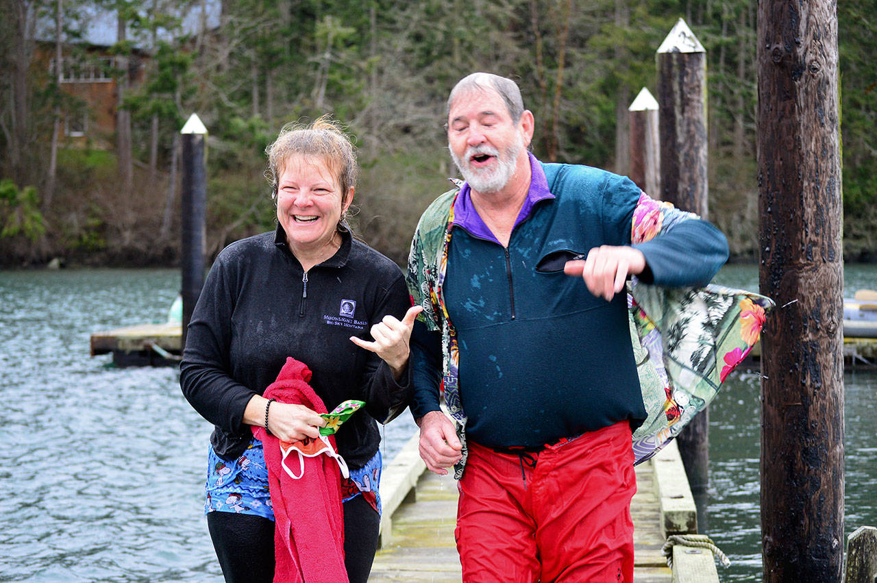 As two of the jumpers-in around noon New Year’s Day, Capt. Jeff Sanders and Laurie Darleen found the saltwater invigorating. Diane Urbani de la Paz/Peninsula Daily News