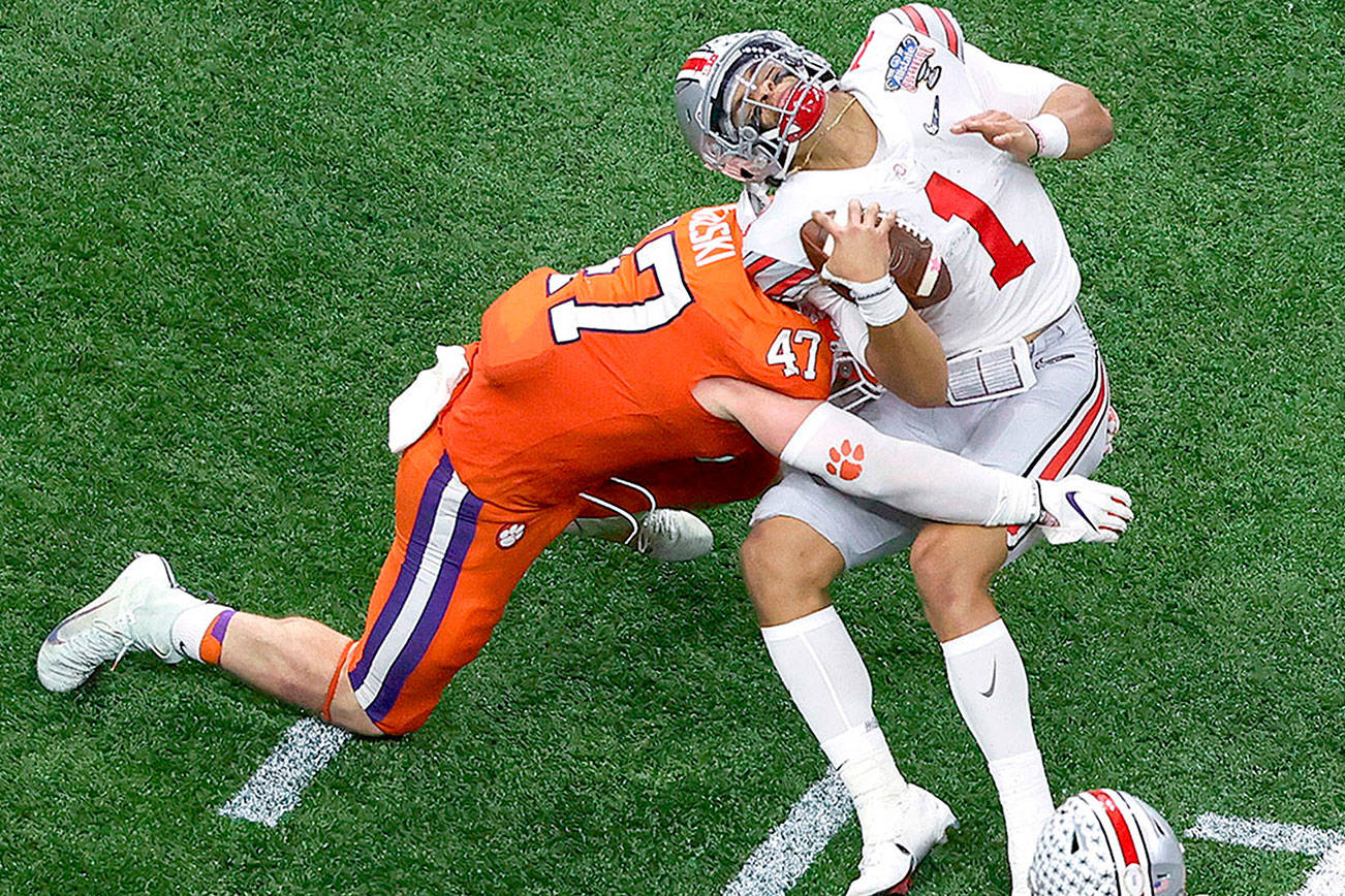 Ohio State quarterback Justin Fields gets hit by Clemson linebacker James Skalski during the first half of the Sugar Bowl NCAA college football game Friday, Jan. 1, 2021, in New Orleans. Skalski was ejected from the game for targeting. (AP Photo/Butch Dill)