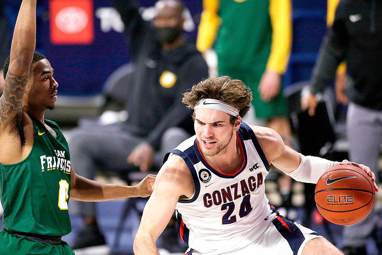 Gonzaga forward Corey Kispert, right, dribbles while pressured by San Francisco guard Khalil Shabazz during the first half of an NCAA college basketball game in Spokane, Wash., Saturday, Jan. 2, 2021. (AP Photo/Young Kwak)