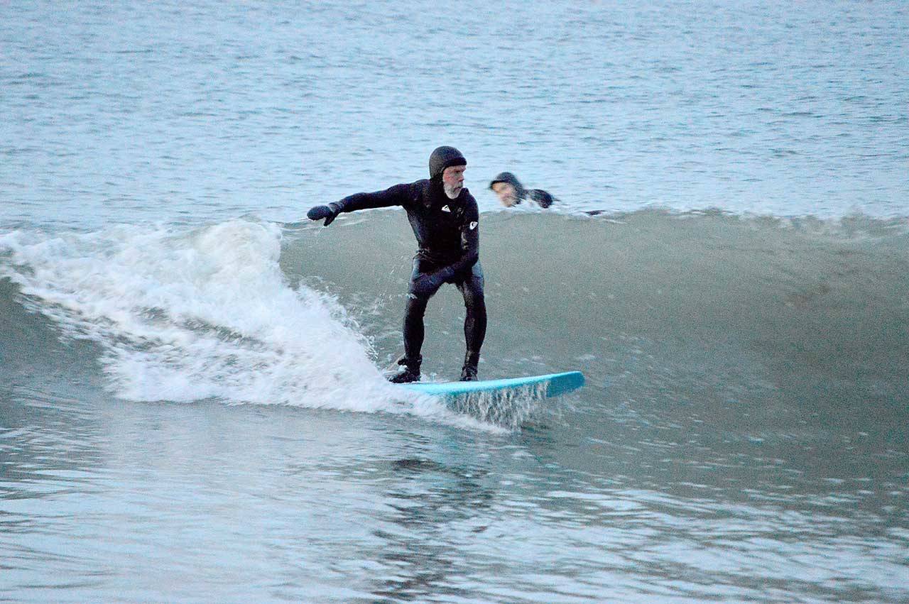 Piper Dunlap of Port Townsend rides the cold waves at North Beach County Park, where he and four other surfers stayed Sunday evening until it was too dark to see. (Diane Urbani de la Paz/Peninsula Daily News)