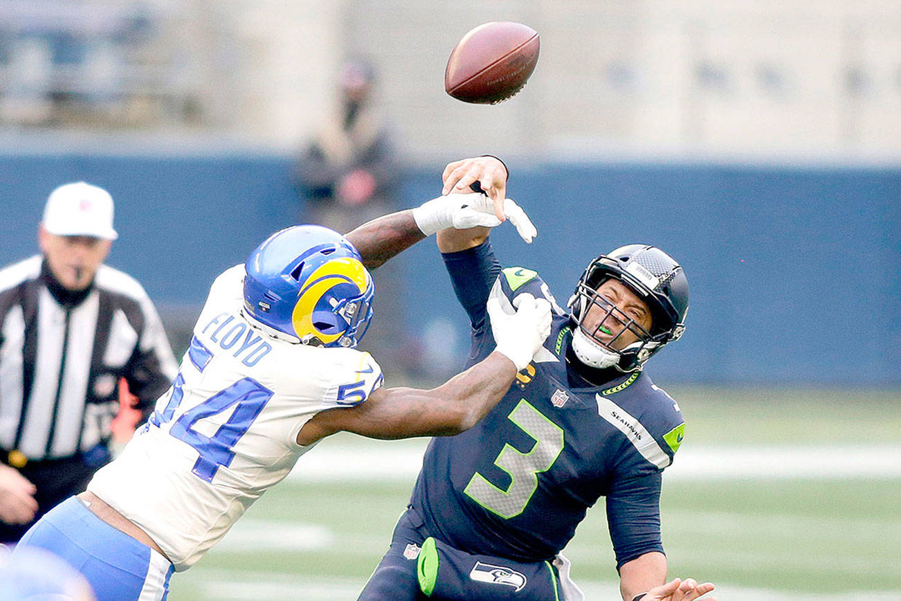Los Angeles Rams outside linebacker Leonard Floyd (54) knocks the ball away as Seattle Seahawks quarterback Russell Wilson tries to pass during the first half of an NFL wild-card playoff football game, Saturday, Jan. 9, 2021, in Seattle. (AP Photo/Scott Eklund)