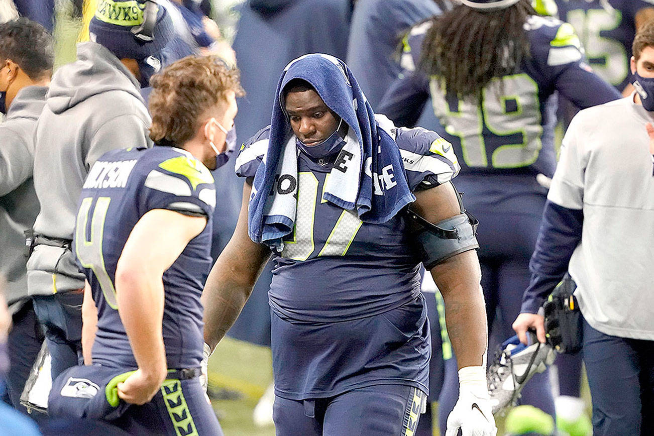 Seattle Seahawks defensive tackle Poona Ford turns away from the field as he stands at the bench late in the second half of an NFL wild-card playoff football game against the Los Angeles Rams, Saturday, Jan. 9, 2021, in Seattle. (AP Photo/Ted S. Warren)
