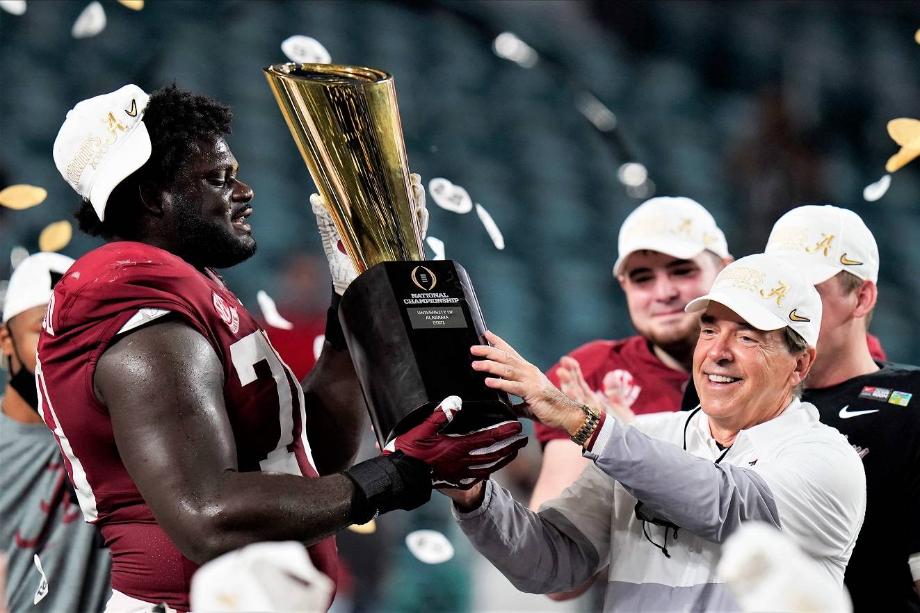 Alabama head coach Nick Saban and offensive lineman Alex Leatherwood hold the trophy after their win against Ohio State in an NCAA College Football Playoff national championship game, Tuesday, Jan. 12, 2021, in Miami Gardens, Fla. Alabama won 52-24. (AP Photo/Chris O'Meara)