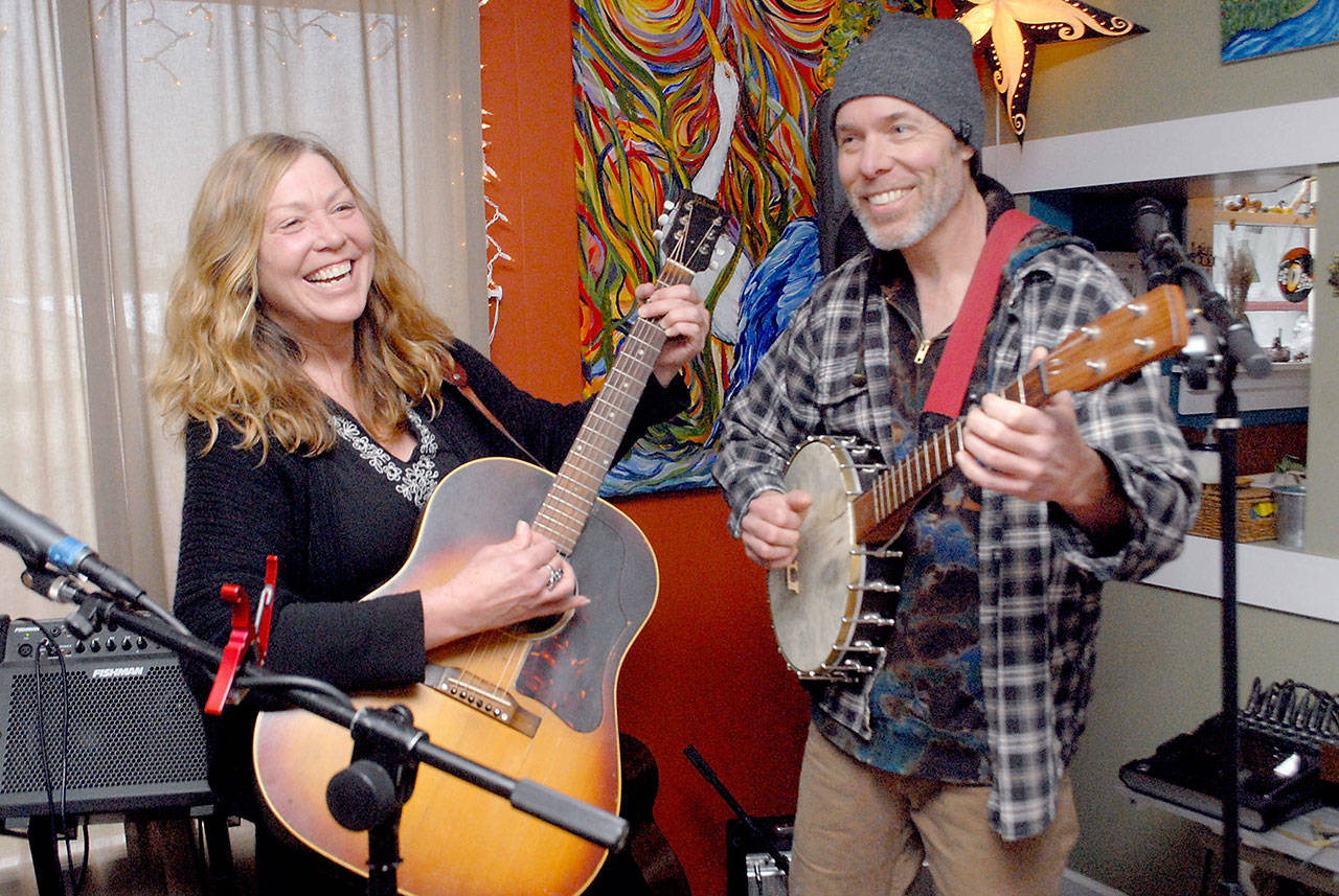 Kim Trenerry and Jason Mogi, who perform as Deadwood Revival, practice in their Port Angeles home on Thursday in preparation for a live-streamed concert for the Juan de Fuca Foundation’s Winter Benefit on Saturday night. (Keith Thorpe/Peninsula Daily News)