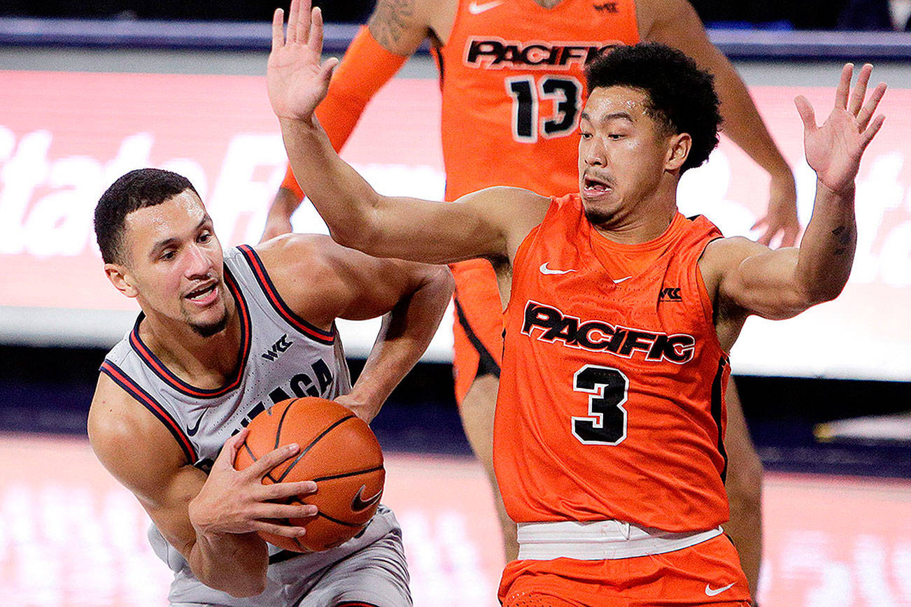 Gonzaga guard Jalen Suggs, left, drives while pressured by Pacific guard Pierre Crockrell II during the first half of an NCAA college basketball game in Spokane, Wash., Saturday, Jan. 23, 2021. (AP Photo/Young Kwak)