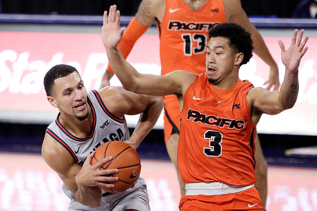 Gonzaga guard Jalen Suggs, left, drives while pressured by Pacific guard Pierre Crockrell II in Spokane on Saturday. (Young Kwak/The Associated Press)