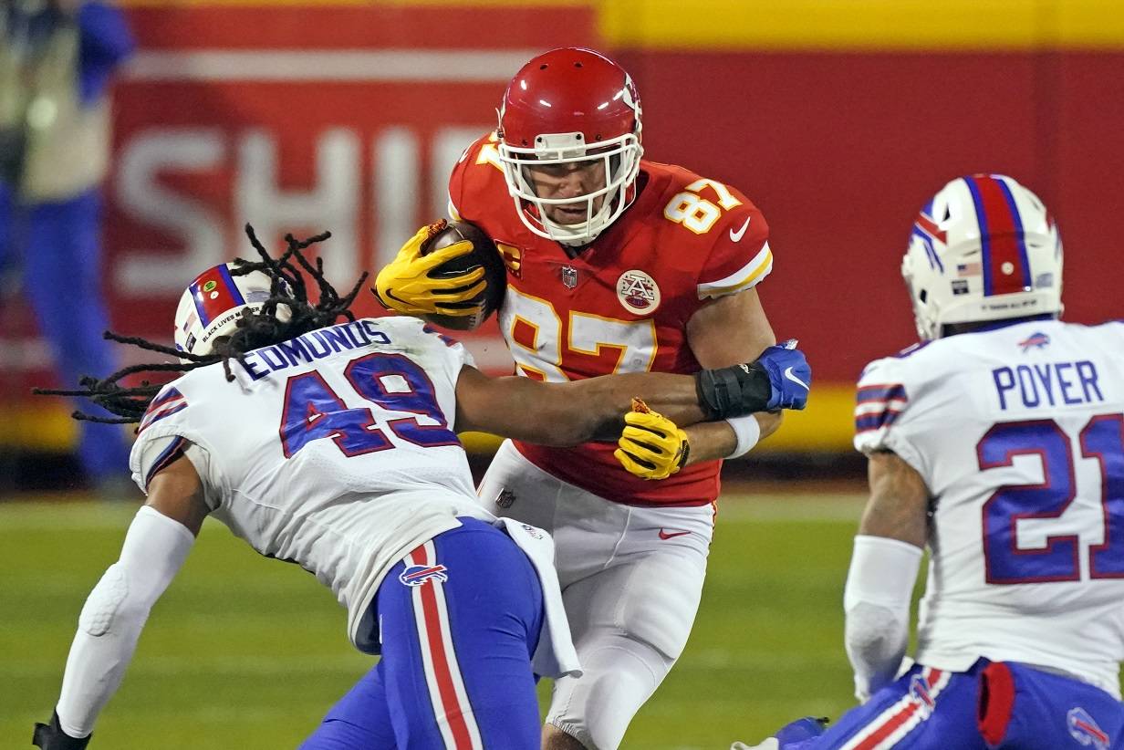 Kansas City Chiefs tight end Travis Kelce (87) runs from Buffalo Bills linebacker Tremaine Edmunds (49) and safety Jordan Poyer (21) after catching a pass during the first half of the AFC championship NFL football game, Sunday, Jan. 24, 2021, in Kansas City, Mo. (AP Photo/Charlie Riedel)