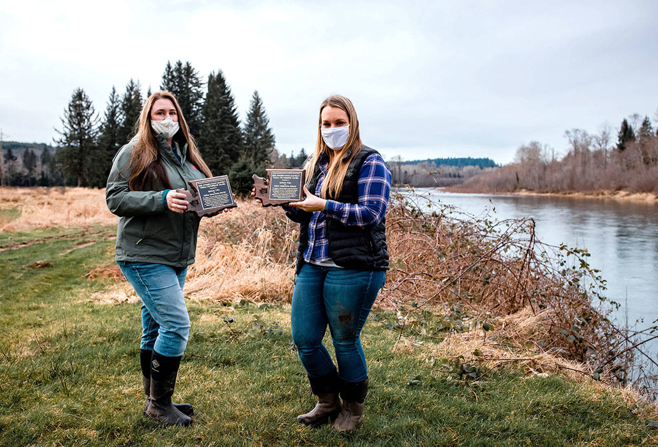 Nicole Rasmussen, water quality biologist for the Quileute Tribe (right), and Meghan Adamire, conservation planner for Clallam Conservation District, standing along the edge of the Quillayute River with the Hermison Road restoration project in the background. (Submitted photo)