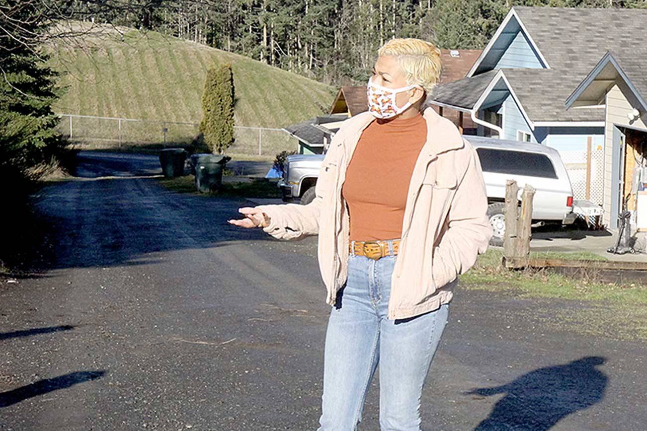 Sidney Murphy stands in the alley behind her home on West 13th Street in Port Angeles. The dirt alley also is the front driveway to several homes build on a sloping hillside and it's the only access for emergency services. (Dave Logan/For Peninsula Daily News)