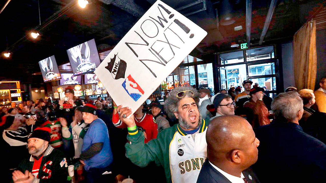 Elaine Thompson/The Associated Press
The late Kris “Sonic Guy” Brannon holds up a sign in support of adding an NBA team following the announcement of a new NHL hockey team in Seattle, at a celebratory party in December 2018, in Seattle.