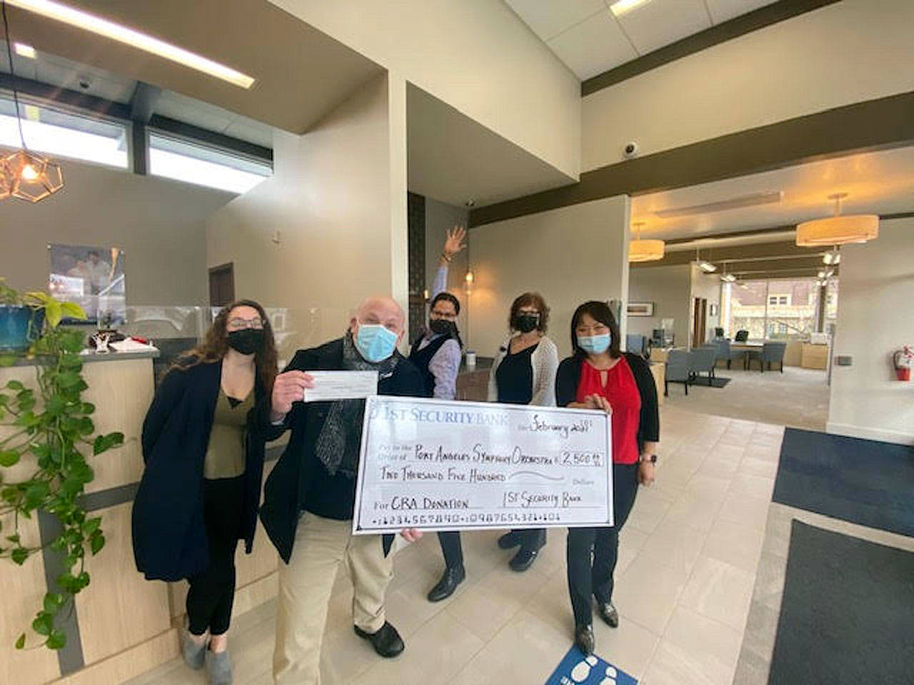 Port Angeles Symphony conductor and music director Jonathan Pasternack, foreground, accepted a major donation for the Adventures in Music program from 1st Security Bank earlier this month. With him at the Sequim branch are, from left, bank staff member Danielle Lorentzen, assistant manager Tyrone Beatty, branch manager Elisa Simonsen and personal banker Rui Starrett. (photo courtesy Port Angeles Symphony)