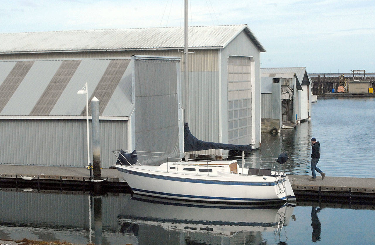 A boat sits moored next to several boathouses at Port Angeles Boat Haven on Thursday. Port of Port Angeles commissioners are suggesting replacing boat houses with floating homes. (Keith Thorpe/Peninsula Daily News)