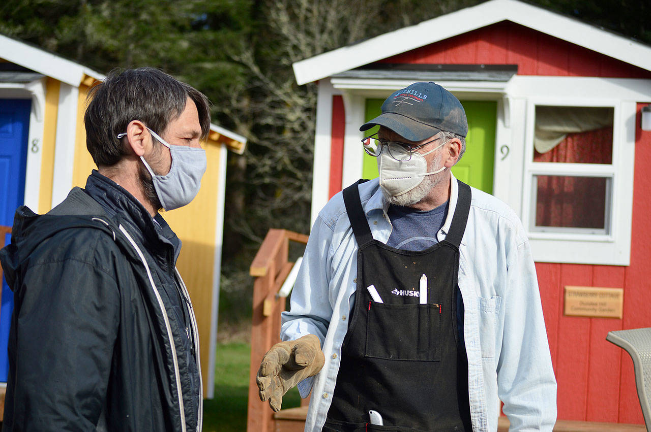 Boeing Bluebills volunteer Dan Nieuwsma, right, talks with Bayside Housing Services case manager Mike Schleckser about building ramps to the shower units at Peter’s Place. (Diane Urbani de la Paz/Peninsula Daily News)