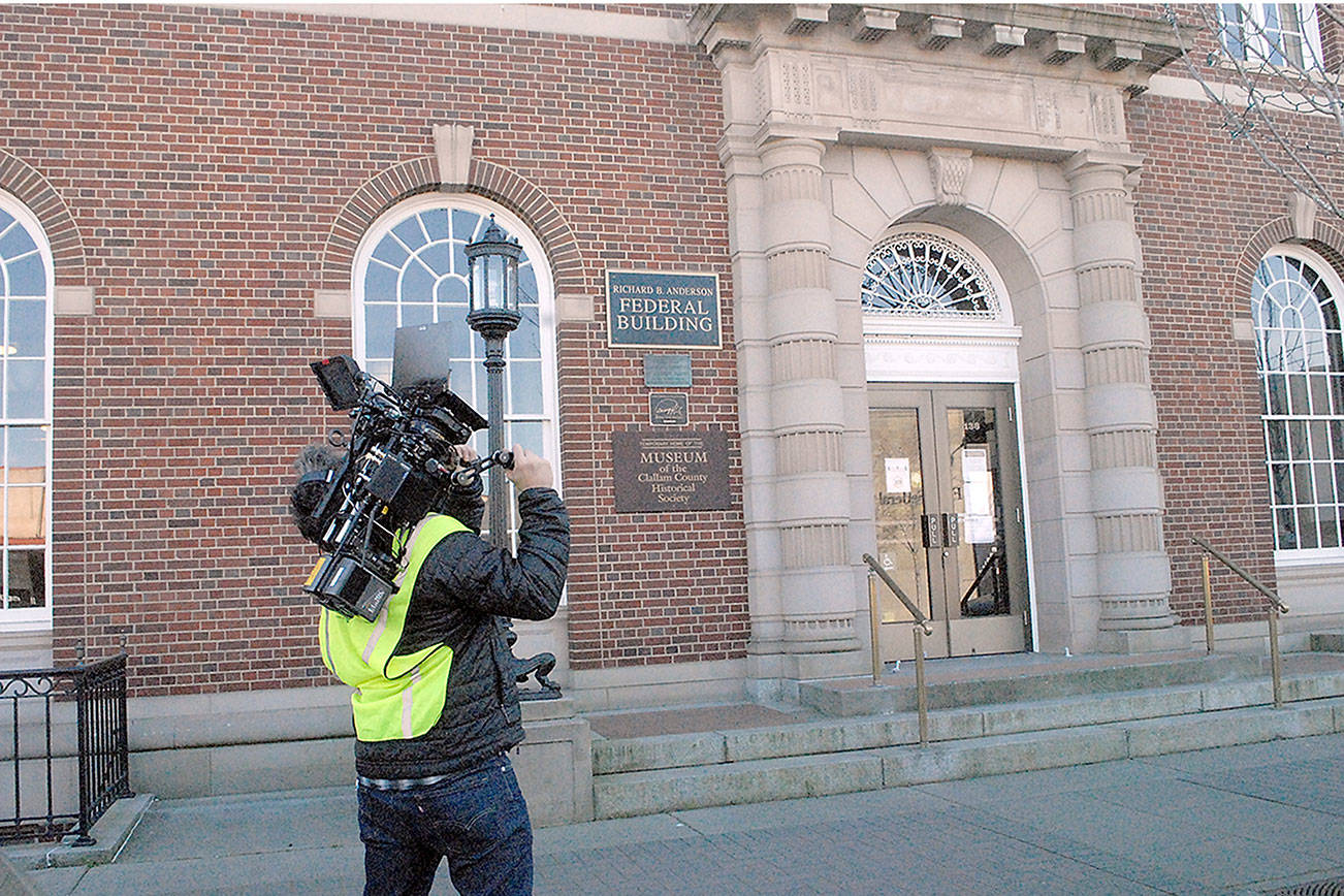 Videographer Paul Mailman of Santa Monica, Calif.,-based Furlined Commercial Production Co. films building exteriors of the Richard B. Anderson Federal Building in Port Angeles on Friday for an upcoming commercial for a cell phone service provider. The crew spent Friday afternoon taping scenes from around downtown and were scheduled to record a scene with live actors Saturday. (Keith Thorpe/Peninsula Daily News)