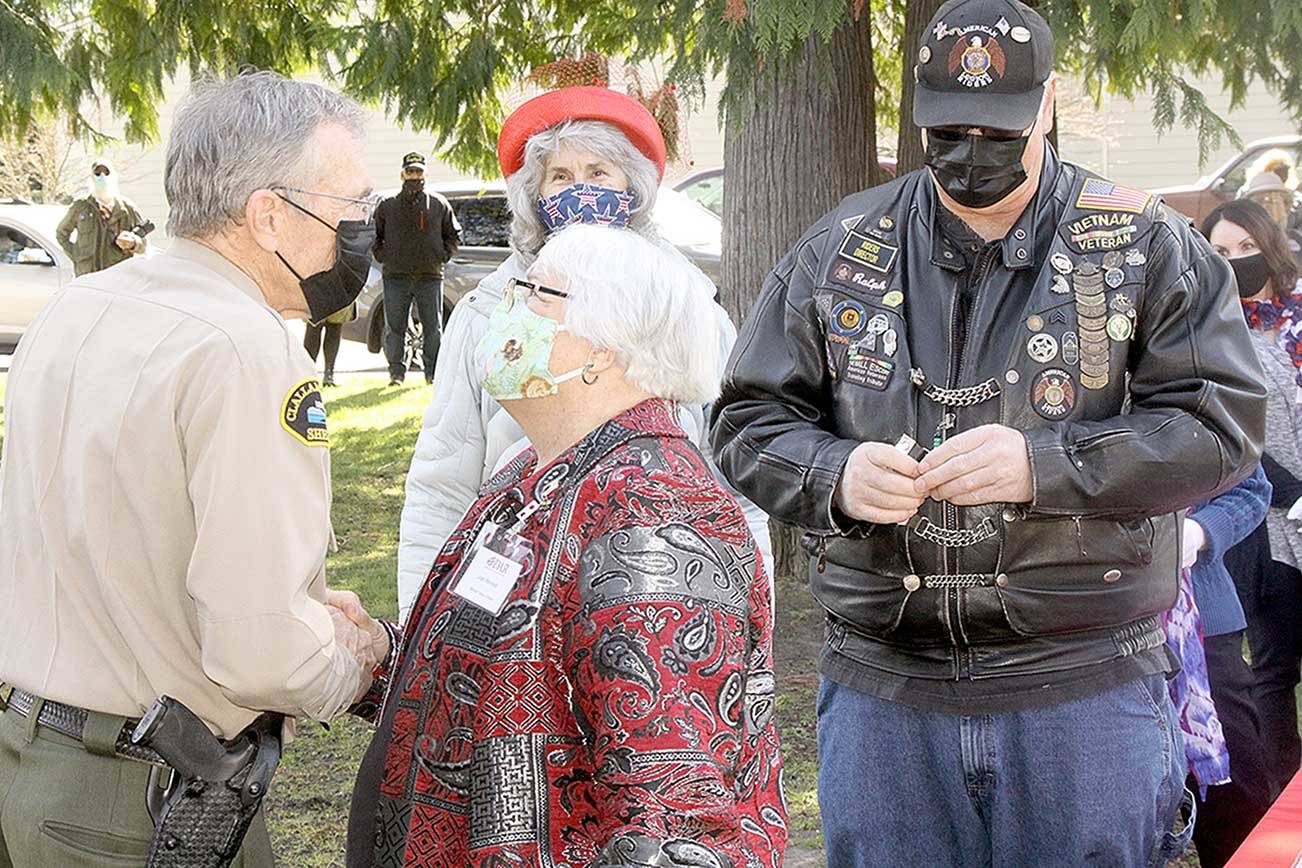 Joan Shields, center, the surviving spouse of Marvin Shields, is presented a commemorative certificate to honor her late husband’s heroic action during the Vietnam war, during which he was fatally wounded. Clallam County Sheriff Bill Benedict, left, presents Shields the award. Benedict, a Vietnam veteran, was presented a commemorative certificate in addition to serving as the keynote speaker. More than 25 Vietnam veterans were honored in the ceremony Monday at the Clallam County Veterans Center. (Dave Logan/For Peninsula Daily News)