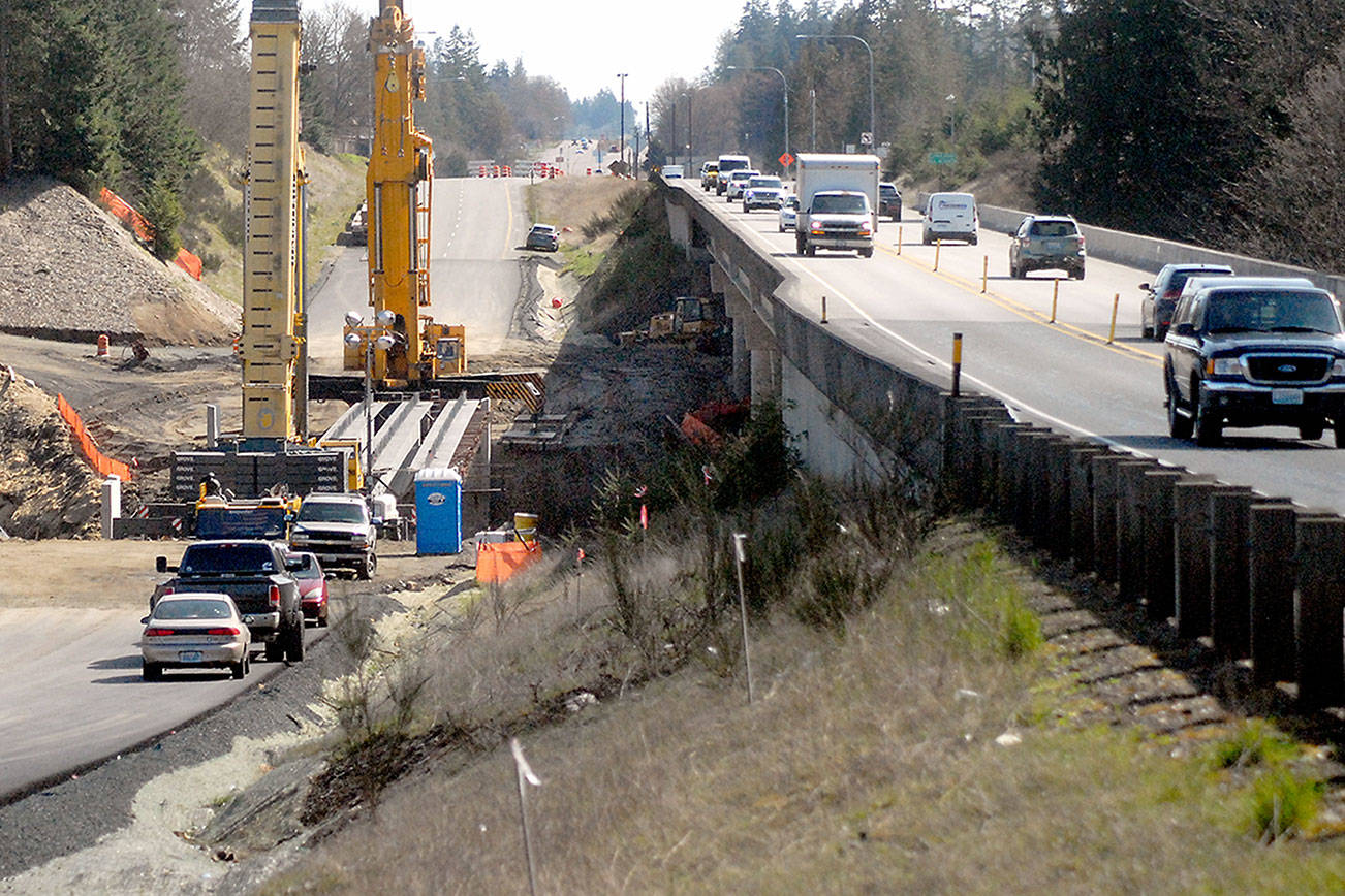Keith Thorpe/Peninsula Daily News
Crains set at the site of the new U.S. 101 bridge over Siebert Creek between Port Angeles and Sequim after three out of six 175-foot-long concrete girders were hoisted into place on Tuesday. Traffic delays of up to 20 minutes at the site are possible today to accommodate heavy machinery used to place the remaning girders occupy the parallel bridge. The project was designed to replace an aging culvert that was a hinderance to fish passage in Siebert Creek with additional culvert removed underway at nearby Bagley Creek. Traffic has been reduced to a single lane in each direction at both construction sites.