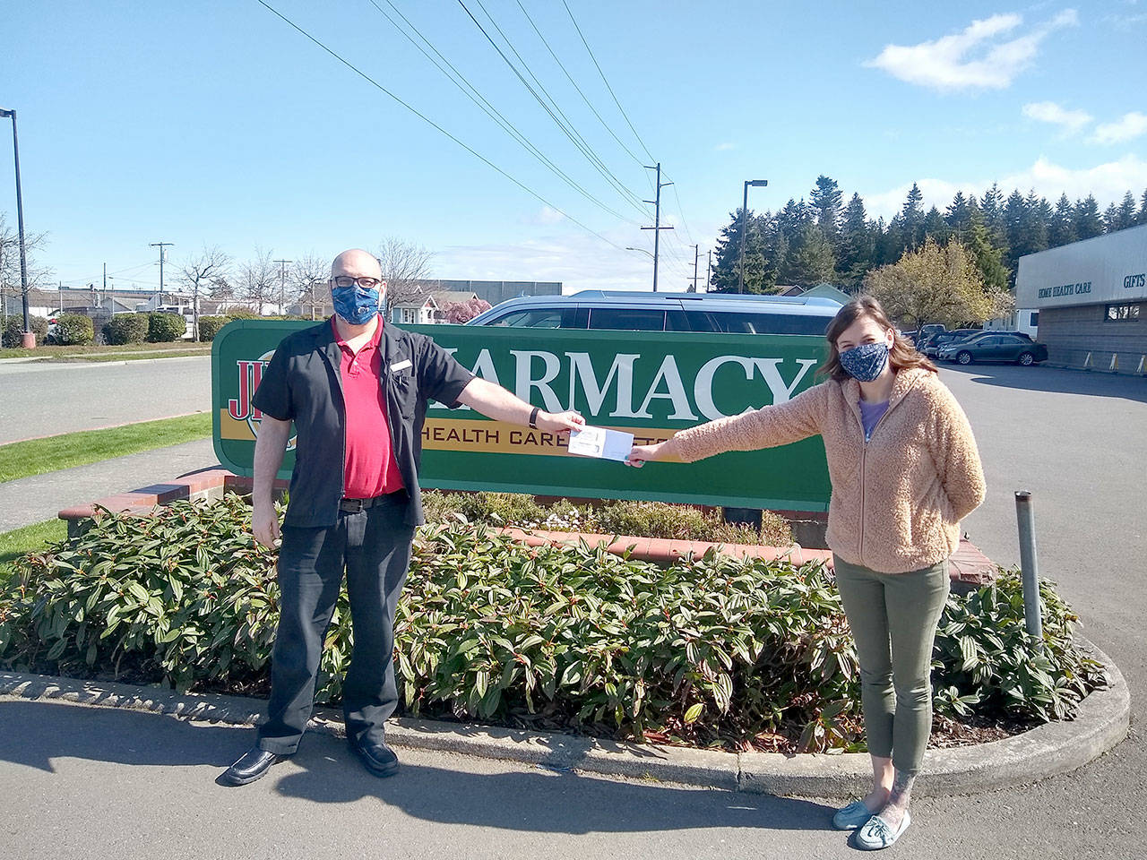 Ryan French, Jim’s home health director, hands a $558.86 check to Hermina Solomon of the Port Angeles Food Bank. The food bank was the January recipient of Jim’s Cares Monthly Charity. The funds are raised through monetary donations, used book sales, donated employee casual days and a percentage of over-the-counter sales at Jim’s.