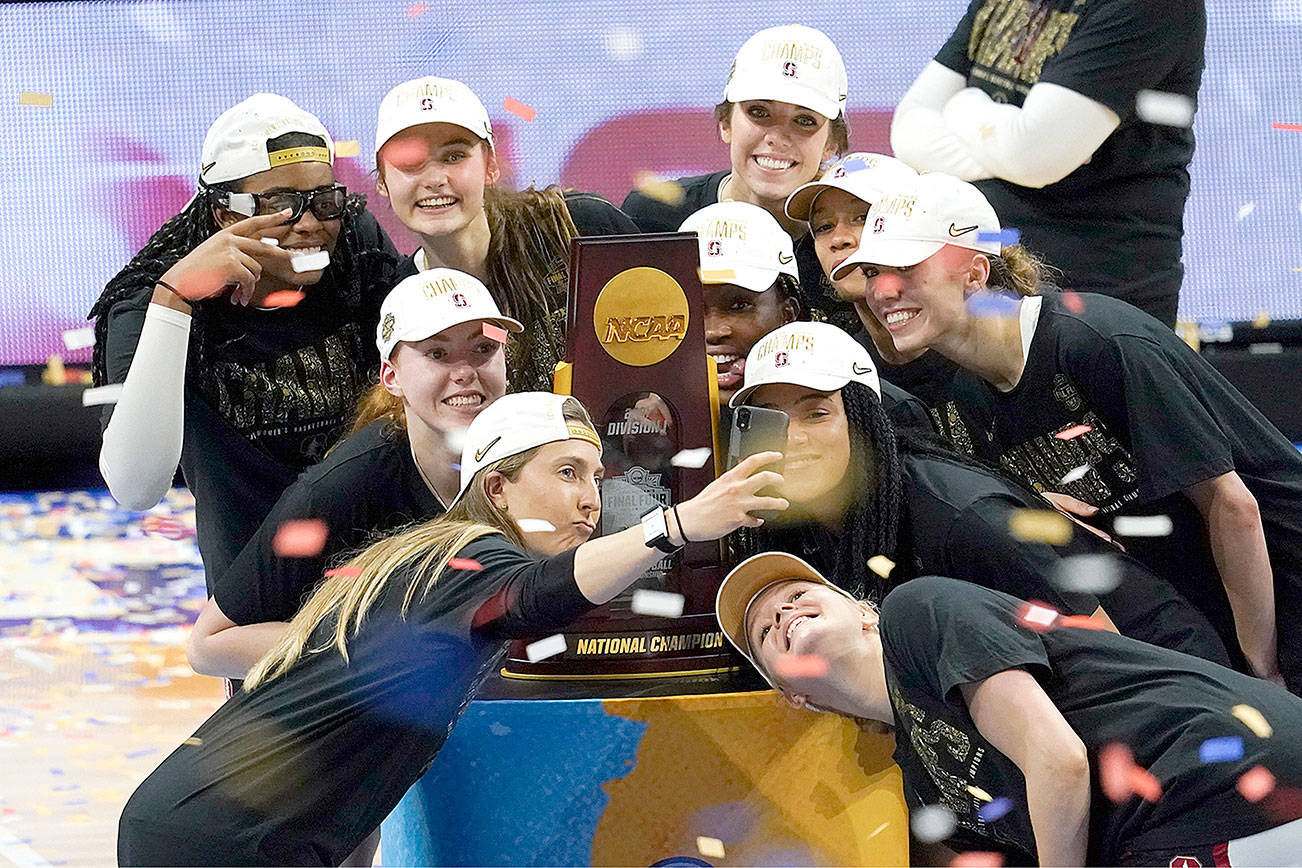 Stanford players celebrate with the trophy after the championship game against Arizona in the women's Final Four NCAA college basketball tournament, Sunday, April 4, 2021, at the Alamodome in San Antonio. Stanford won 54-53. (AP Photo/Eric Gay)