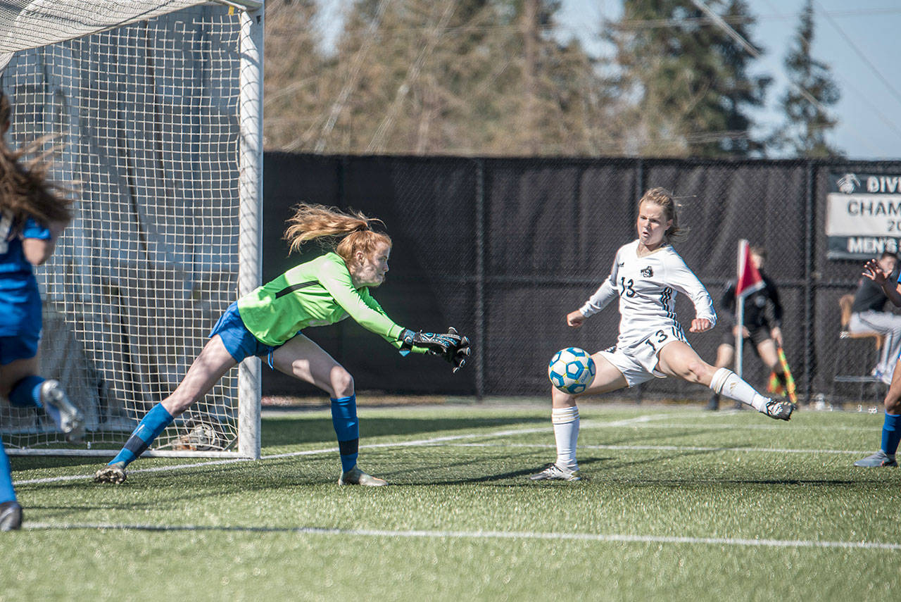 Peninsula’s Makenna Warren, right, sweeps her leg onto a perfectly positioned corner kick from Miya Clark as Edmonds goalkeeper Emily Morandi defends during the Pirates’ 3-0 home opener win Monday. Warren scored a goal on the play. (Jesse Major/for Peninsula Daily News)