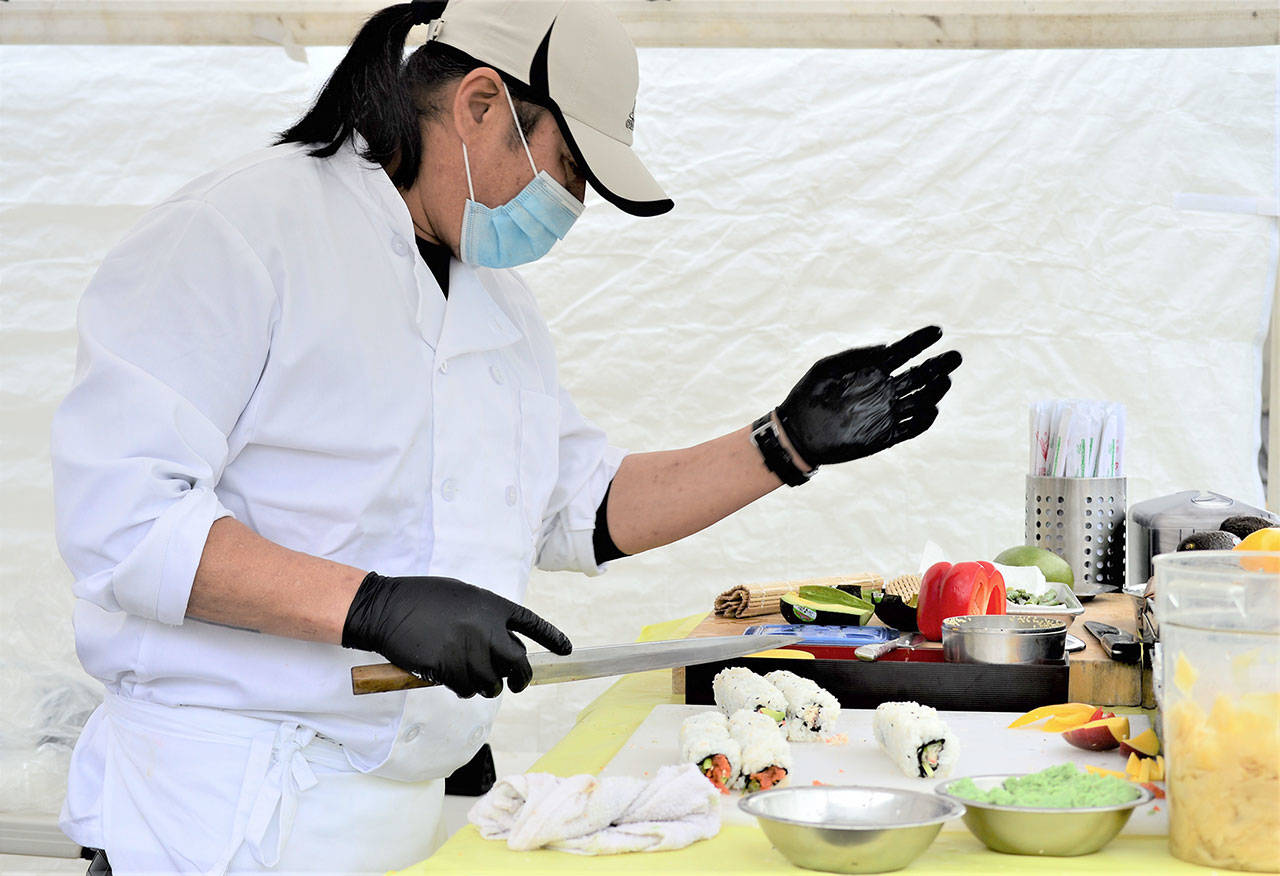 Chef Wyatt Park, pictured in this file photo, shapes his sushi creations at the Jefferson County Farmers Market in Uptown Port Townsend on Saturdays. Along with dozens of other food and artisan vendors, Park mans his stand from 9 a.m. to 2 p.m. at Tyler and Lawrence streets. For those who prefer to shop for fresh produce by computer or mobile device, JCFmarkets.org keeps its online market open for orders till 1 p.m. today. (Diane Urbani de la Paz/Peninsula Daily News)