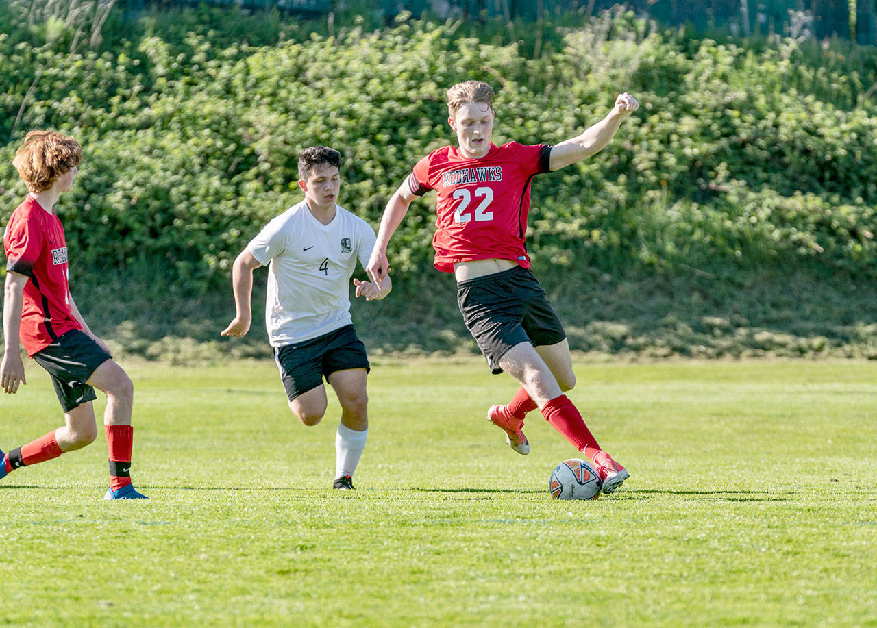 East Jefferson’s Yarrow Dean, right, stops the ball and keeps it from Klahowya’s Oscar Peterson as East Jefferson’s Mark Anderson watches the play during a game at Memorial Field in Port Townsend on Tuesday. (Steve Mullensky/for Peninsula Daily News)