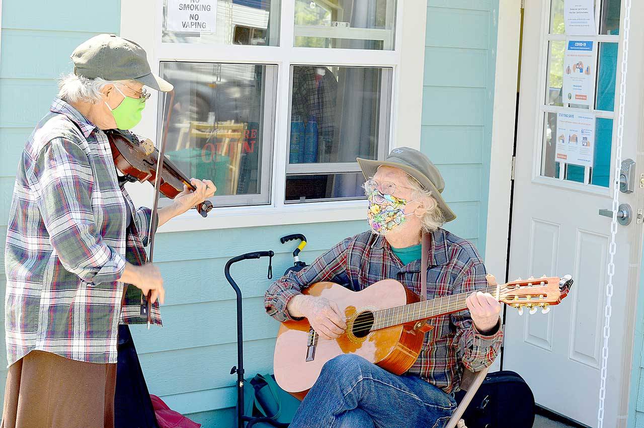 Fiddler Alea Waters, left, and guitarist Lang Russel provide free music outside Port Townsend’s Recovery Cafe last week. (Diane Urbani de la Paz/Peninsula Daily News)