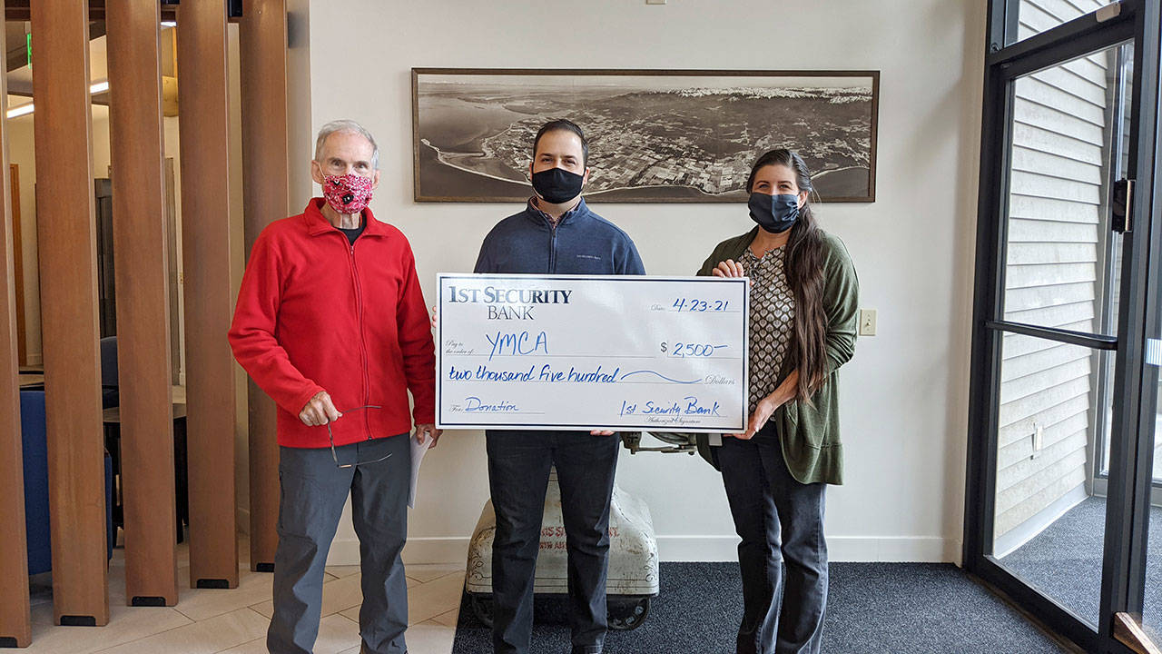 Gary Huff, left, board director and campaign chairman for the Olympic Peninsula YMCA’s 2021 Impact Campaign, accepts a donation for the YMCA from 1st Security Bank, represented by Vice President Branch Manager Anthony Aceto and 1st Security personal banker Sheena Zahn. (Photo courtesy of Olympic Peninsula YMCA)