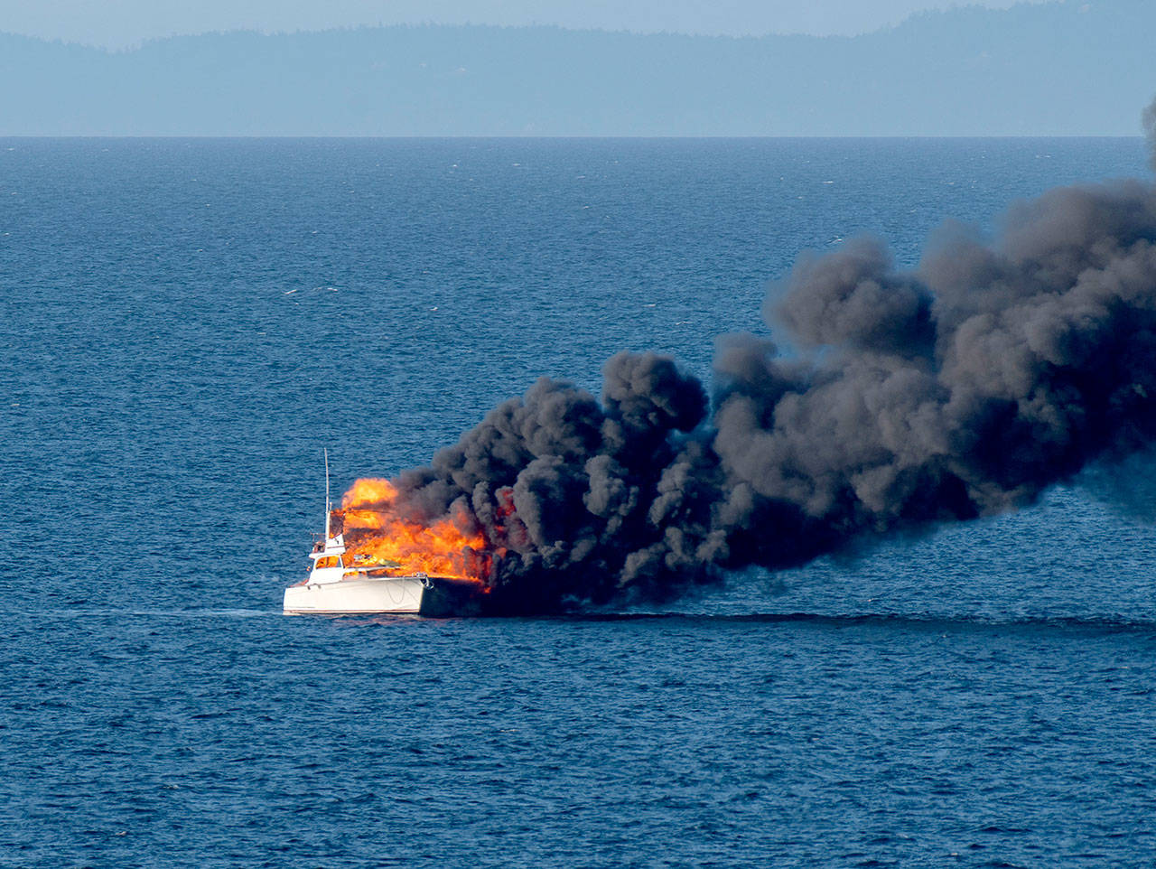 A 48-foot fishing yacht burns in the Strait of Juan de Fuca in this photograph captured by Port Angeles resident Ken Campbell.