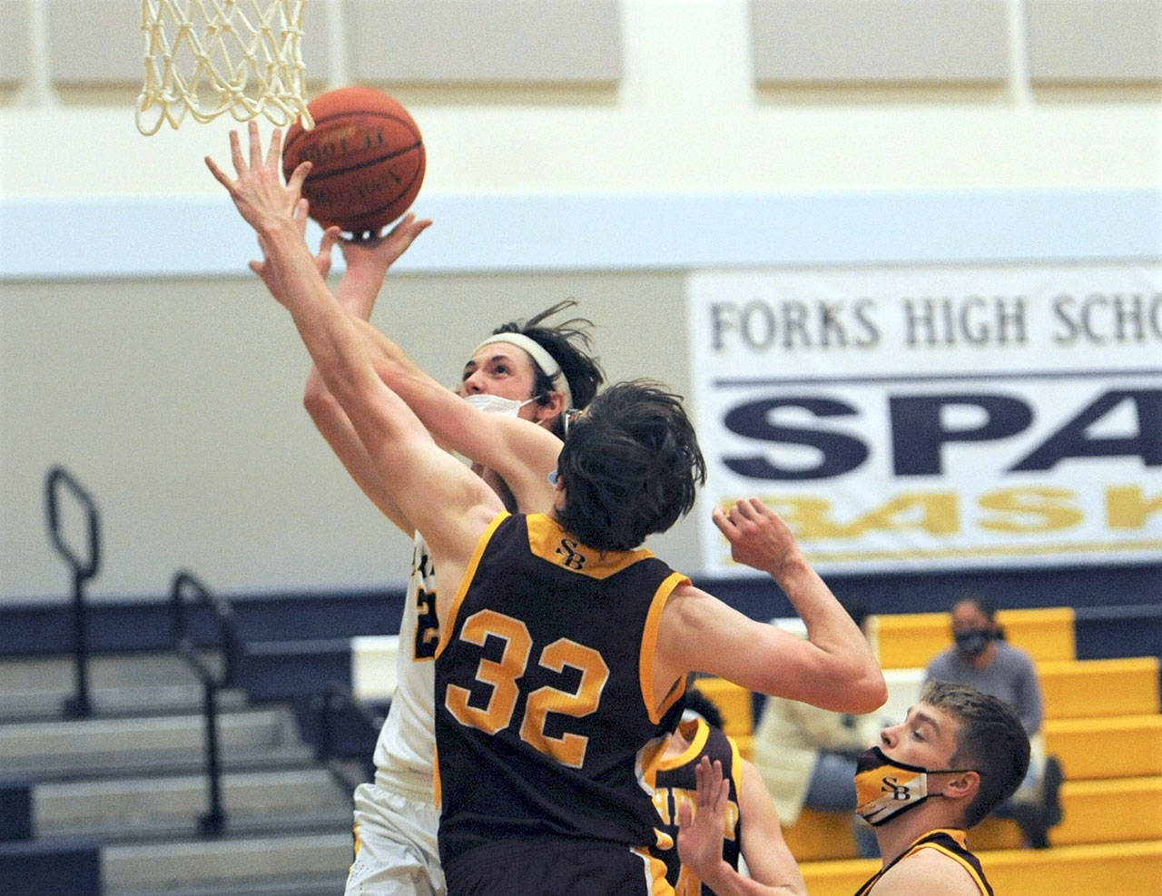 Forks’ Raymond Davis scores over South Bend’s Steven Kirpes during the Spartans’ 84-30 Pacific League win over the Indians. Davis had 12 points in the game. (Lonnie Archibald/for Peninsula Daily News)