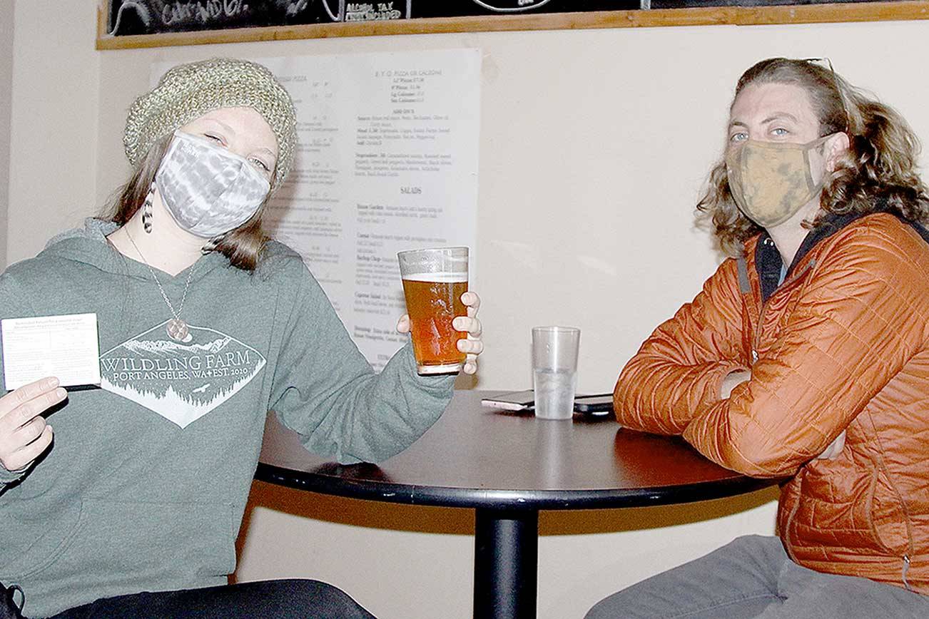 Rachel and Daniel Shyles were among nearly 30 people to attend a COVID-19 popup clinic at Barhop Brewing and Taproom for a free beer to go along with a free vaccine. Rachel got her second shot of Moderna vaccine on Saturday. Daniel said he already had two inoculations. The service was provided by the Clallam County Health and Human Services department. (Dave Logan/for Peninsula Daily News)