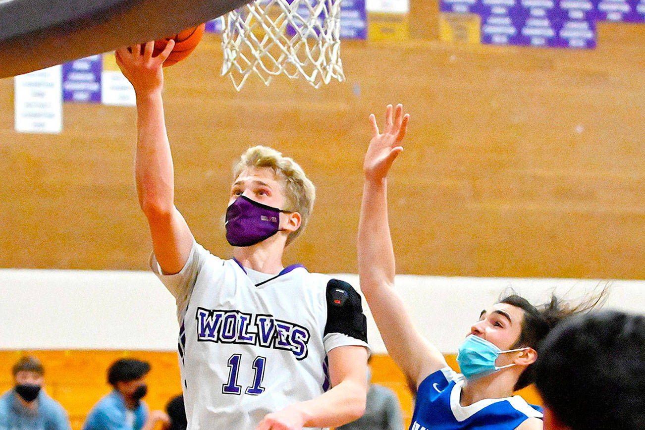 Michael Dashiell/Olympic Peninsula News Group
Sequim's Erik Christiansen goes up for a layup past East Jefferson's Lonnie Kenney in Monday night's game in Sequim.