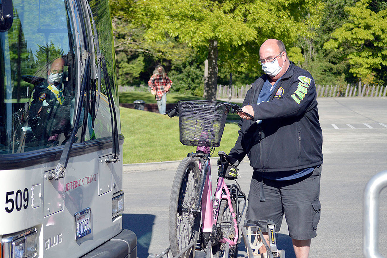 Jefferson Transit driver Lloyd Eisenman loads an electric bicycle onto the rack of the Sequim-bound bus Friday at the Haines Place transit center in Port Townsend. Heavy e-bikes must ride in the rack position closest to the bus’ bumper to avoid stressing the rack. (Diane Urbani de la Paz/Peninsula Daily News)