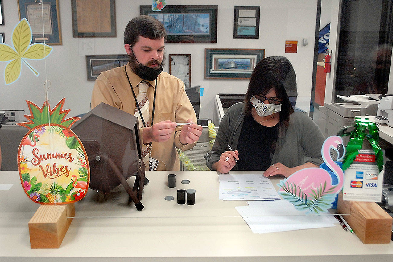 Keith Thorpe/Peninsula Daily News
Protected from the public by a clear barrier, Clallam County Elections Deputy Chris Umbarger, left, reads off candidates names after a lot draw to determine how candidates will be listed on the ballot as Elections Surpervisor Susan Johnson records the results on Friday at the Clallam County Courthouse in Port Angeles.