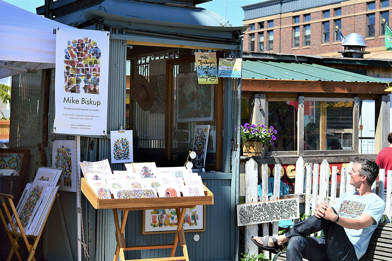Artist Mike Biskup takes in the sun on Water Street in Port Townsend, where he sells his art from a vintage elevator cage. Diane Urbani de la Paz/Peninsula Daily News