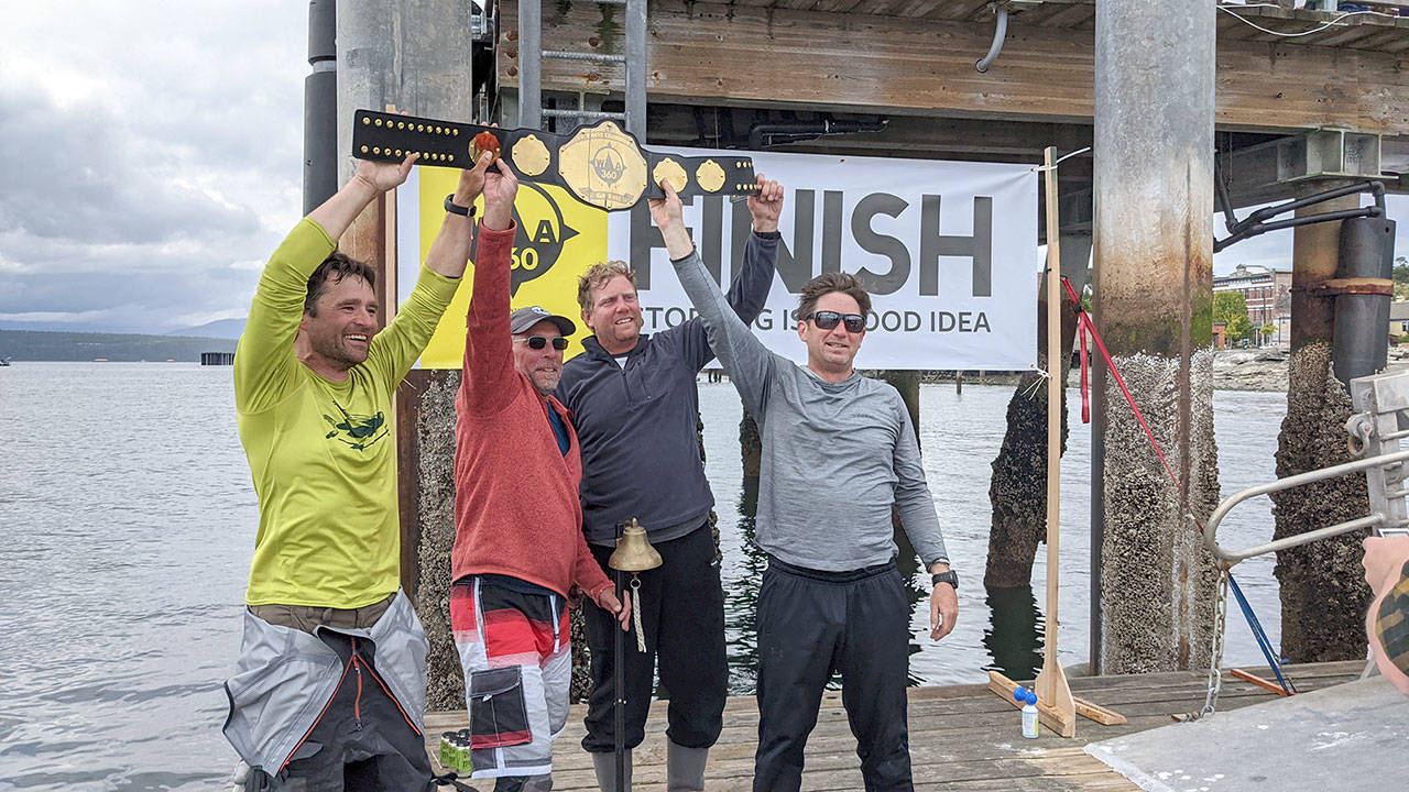 Team High Seas Drifters Scott Wood, left, Mark Boston, Shad Lemke and Jefferson Franklin finished first and rang the bell while hoisting the first place belt for the WA360 on Thursday. The team finished the 360-mile race at 12:59 p.m., after leaving Port Townsend at 6 a.m. Monday. (Zach Jablonski/Peninsula Daily News)
