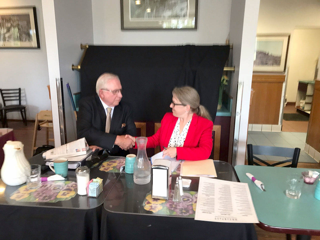 John Procter and Kate Dexter shake hands Tuesday following their primary election forum during which third candidate Jon Bruce was absent. (Paul Gottlieb/Peninsula Daily News)