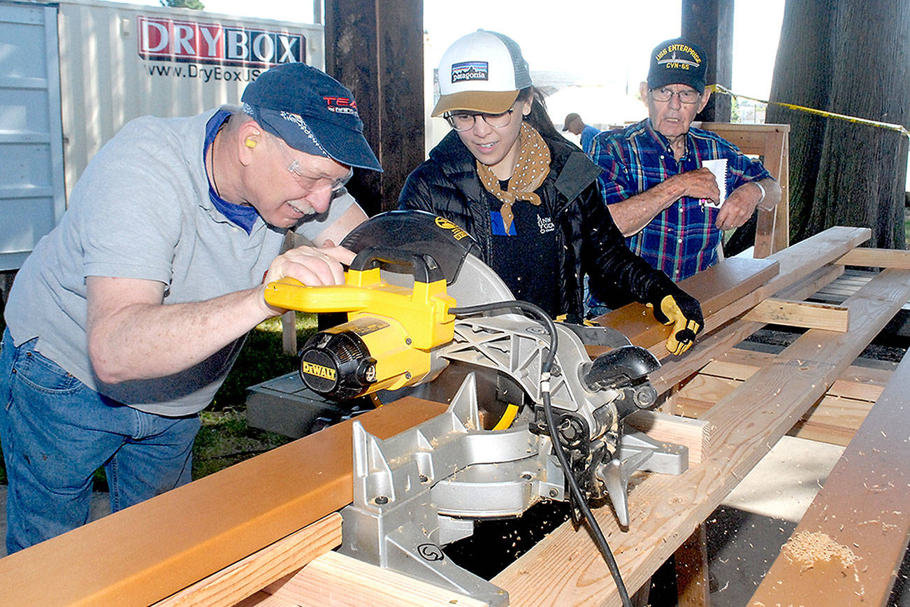 Volunteers, from left, John Albiso, Tien Vo and Bill Chastain cut boards that will become part of the Generation II Dream Playground during the first day of a six-day community build on Tuesday at Erickson Playfield in Port Angeles. The playground will replace an antiquated version that was built by volunteers in 2002 and torn down earlier this year. Organizers are still seeking volunteers to help with construction, the loan of woodworking tools and monetary donations. More information on the build is at www.padreamplayground.org. (Keith Thorpe/Peninsula Daily News)