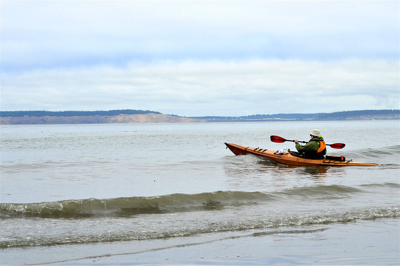 Roy Walker of Port Townsend stays close to shore as he launches his kayak from North Beach County Park on Wednesday morning. Hugging the shore and staying mindful of wind and weather changes are crucial, emergency responders say. (Diane Urbani de la Paz/Peninsula Daily News)