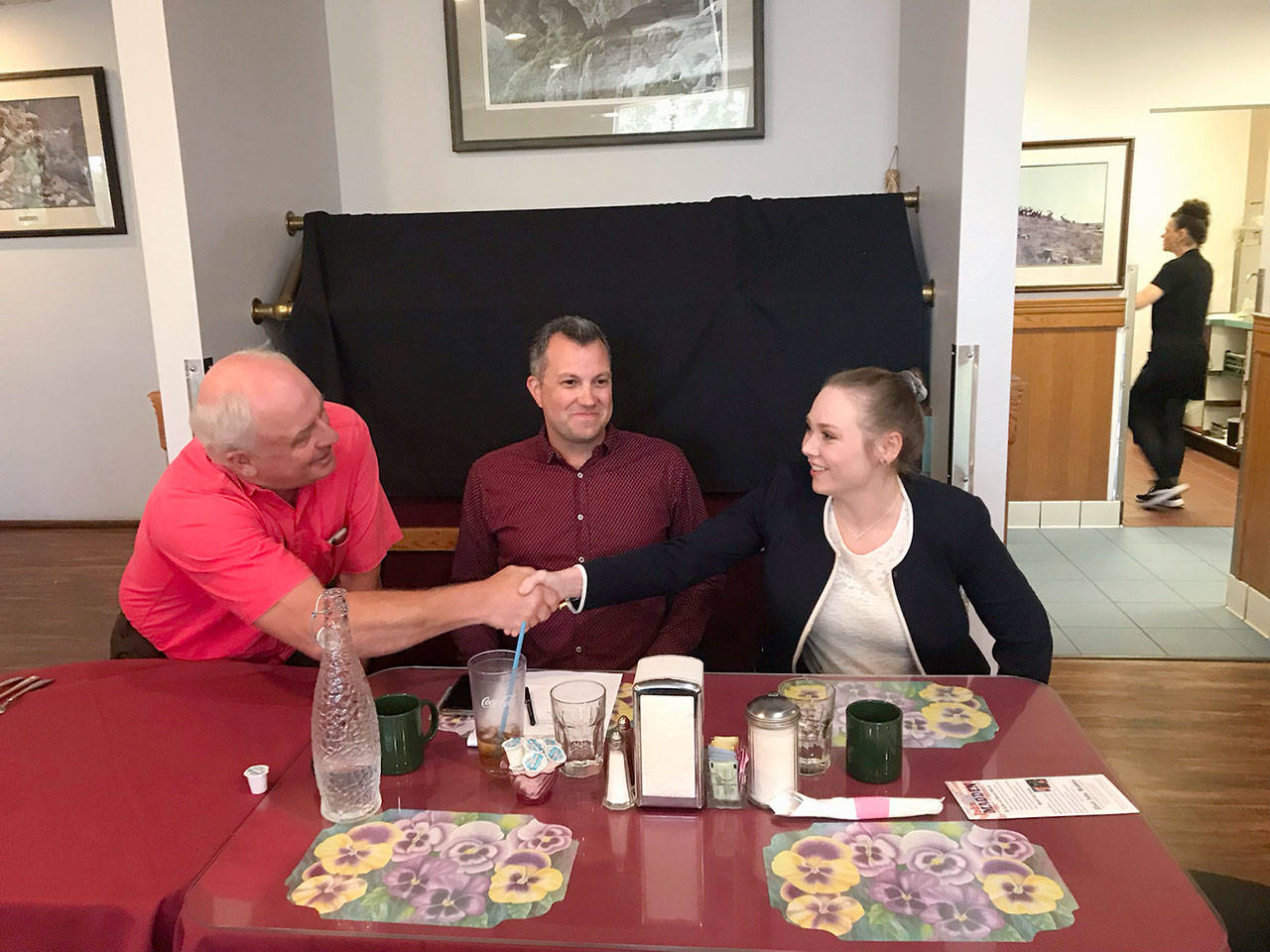 Port Angeles City Council candidates John Madden and Samantha Rodahl shake hands Tuesday following an election forum while incumbent Mike French looks on. (Paul Gottlieb/Peninsula Daily News)