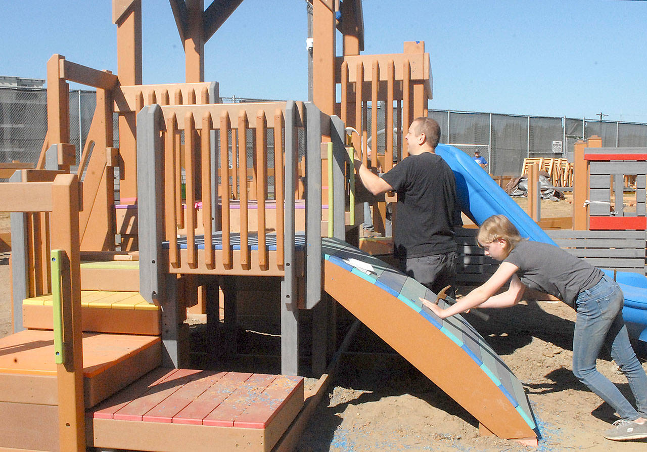 Keith Thorpe/Peninsula Daily News
Cliff Hales of Port Angeles and his daughter, Julie Hales, 14, work on a play structure at the Generation II Dream Playground at Erickson Playfield on Saturday in Port Angeles. Playground organizers held an informal build session attended by about 50 people on Saturday to make progress on portions of the playground left unfinished during last week's six-day community build. The Dream Playground Foundation will hold a two-day community build this Friday and Saturday with the hope of completing playground construction. Signups for the build can be found at padreamplayground.org.