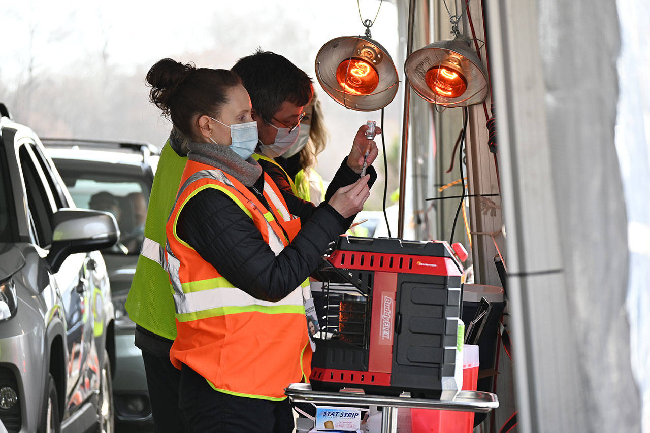 Registered nurses Kelly Bower and Dmitriy Lisenkoff prepare COVID-19 vaccination doses at the Jamestown Family Health Clinic drive-thru clinic in Sequim in March. Michael Dashiell/Olympic Peninsula News Group
