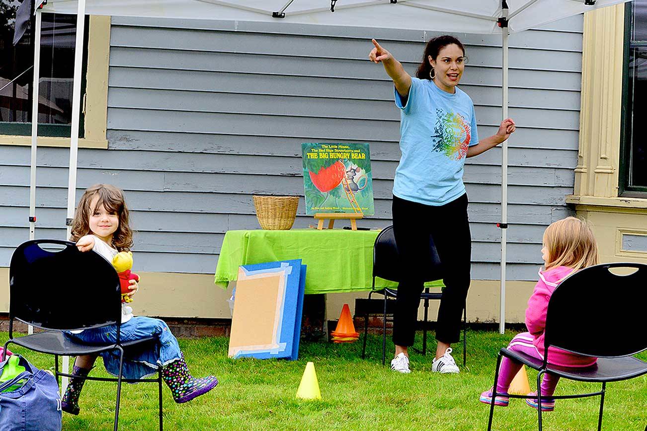 Rosaletta Curry, the Jefferson County Library’s early childhood program coordinator, begins story time by pointing out elements of the environment, such as trees. Ellie Long, 4, left, is among the listeners at story time outside the Port Townsend Library last Thursday. Story hours are offered free at libraries across the North Olympic Peninsula. For information, see NOLS.org and PTpubliclibrary.org. (Diane Urbani de la Paz/Peninsula Daily News)