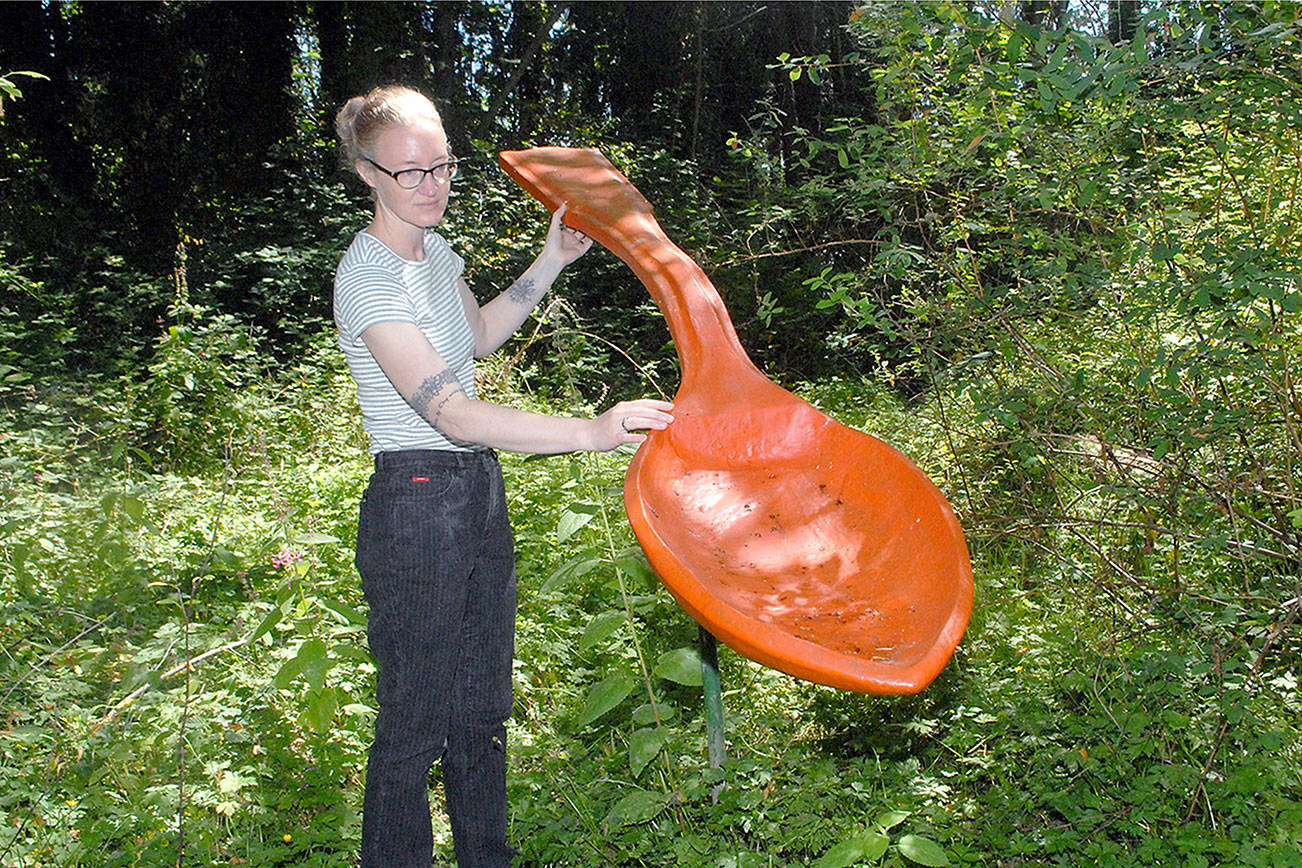 Keith Thorpe/Peninsula Daily News
Sarah Jane, gallery and program director of the Port Angeles Fine Arts Center, admires "Spoonful" by Lucy Congdon Hanson, a featured art installation on Saturday's guided tour of Webster's Woods Sculpture Park.