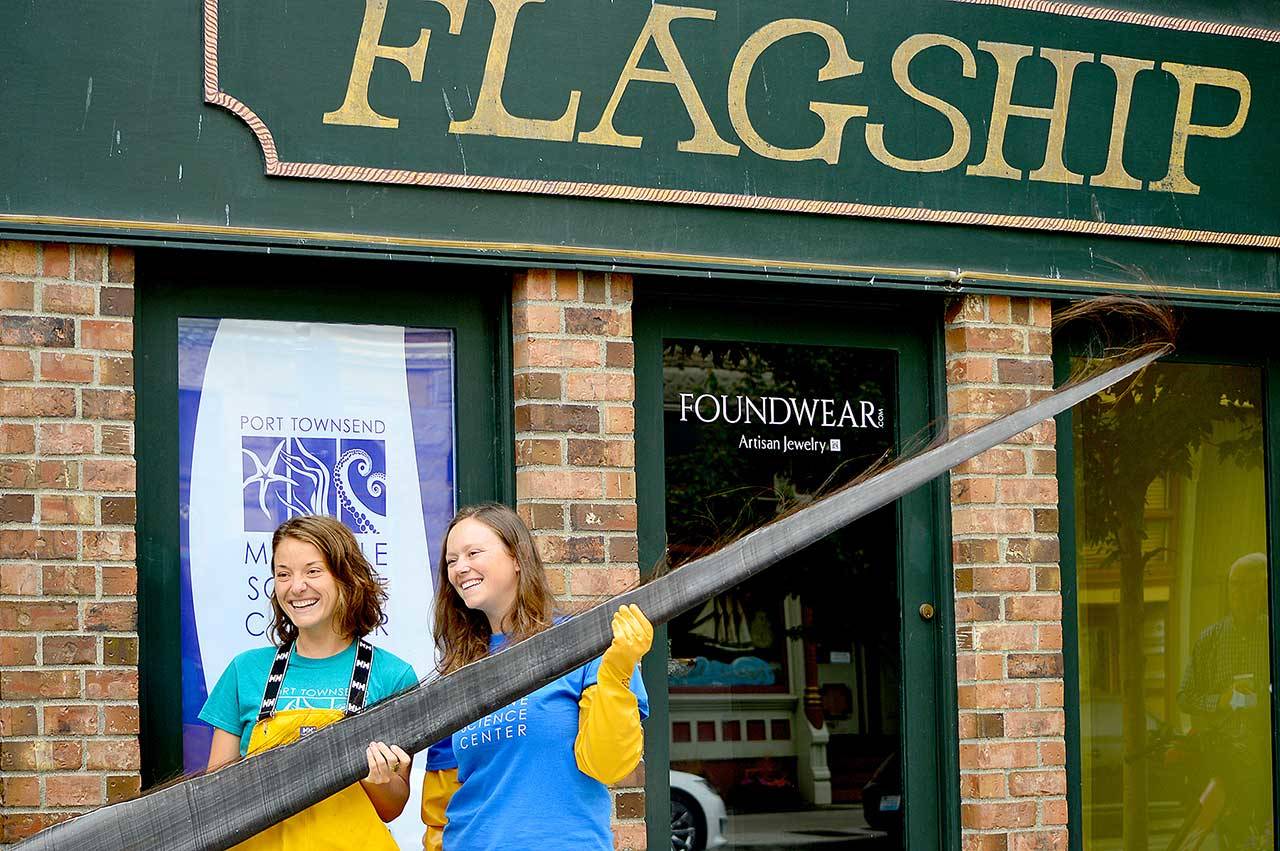 Holding a piece of baleen from a bowhead whale, Port Townsend Marine Science Center exhibit and outreach specialist Mandi Johnson, left, and aquarium specialist Marley Loomis stand before the center’s newly acquired Flagship Landing building in downtown Port Townsend. (Diane Urbani de la Paz/Peninsula Daily News)