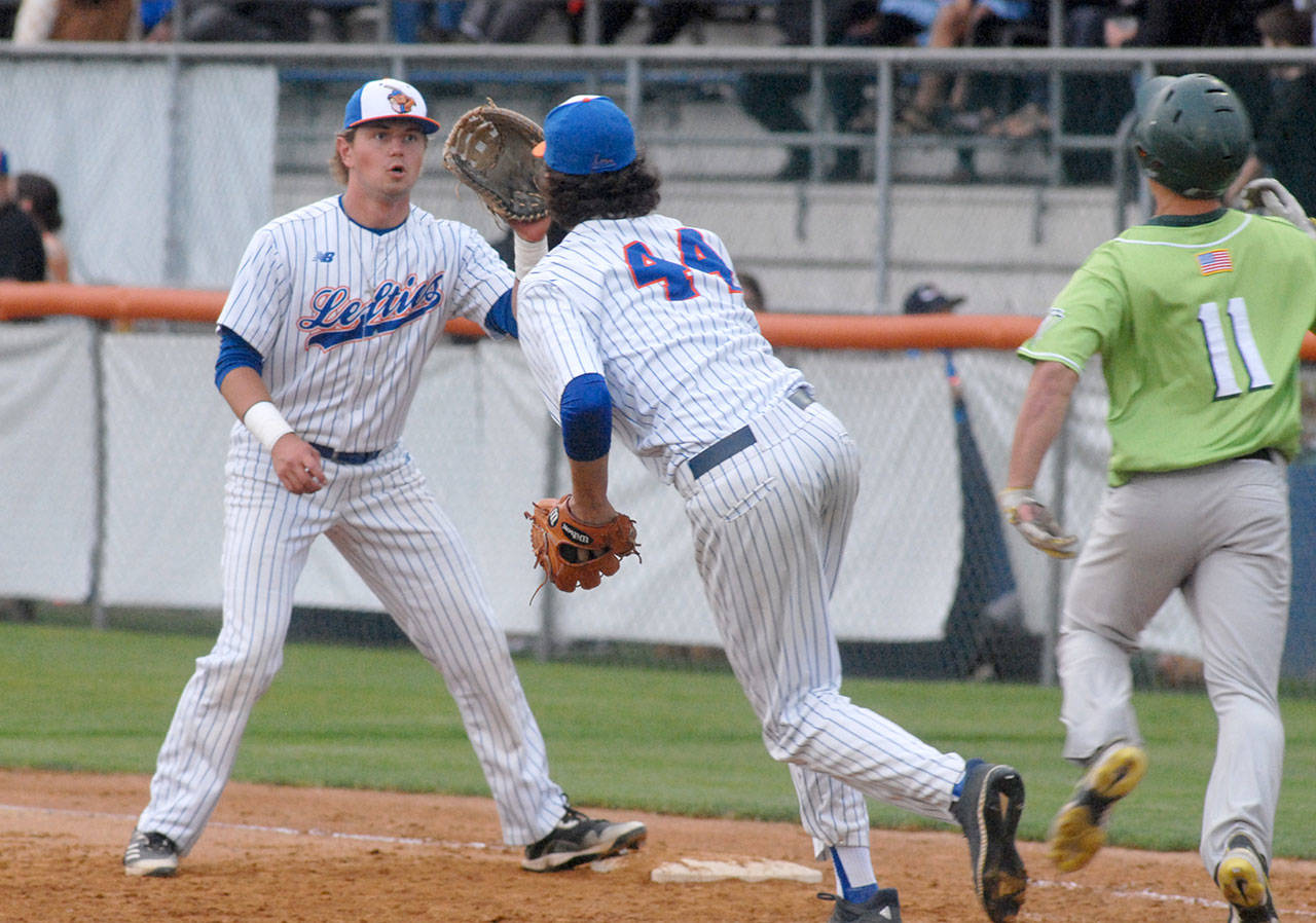 Keith Thorpe/Peninsula Daily News Lefties first baseman Ethan Flodstrom, left, receives a short toss from pitcher Steven Brooks to force out Yakima batter Taylor Holder on an infield dribbler in the third inning on Friday night at Port Angeles Civic Field.