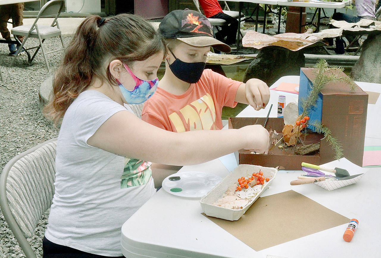 Jasmine Paul, 9, left, and John Hall, 10, put together a habitat diorama in which animals might live in nature after gathering materials in Webster’s Woods at Port Angeles Fine Art Center. (Dave Logan/For Peninsula Daily News)