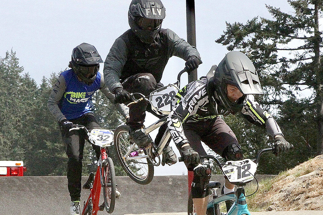 No. 32 Damien Avila of Spokane and No. 228 Vaunn Zimmerman of Redmond doing a little wiggle with his bike trying to get some advantage to overtake the leader and in the lead No. 12 Peyton Calhoun of Port Orchard in Sunday's Gold Cup qualifier at the Lincoln Park BMX track in Port Angeles. (Dave Logan/for Peninsula Daily News)