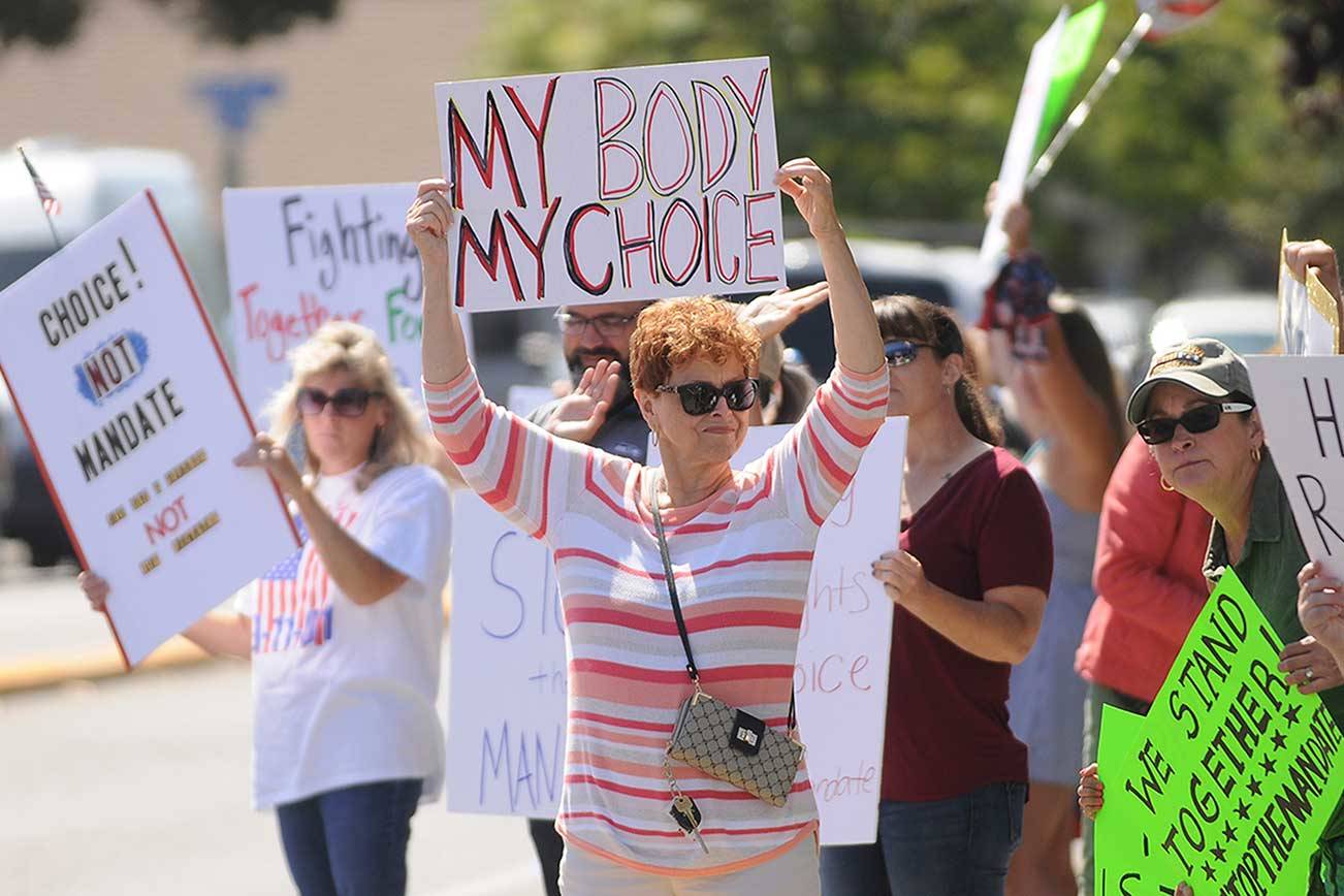 More than 100 protesters fill the corners of Washington Street and Sequim Avenue on Wednesday. (Michael Dashiell/Olympic Peninsula News Group)