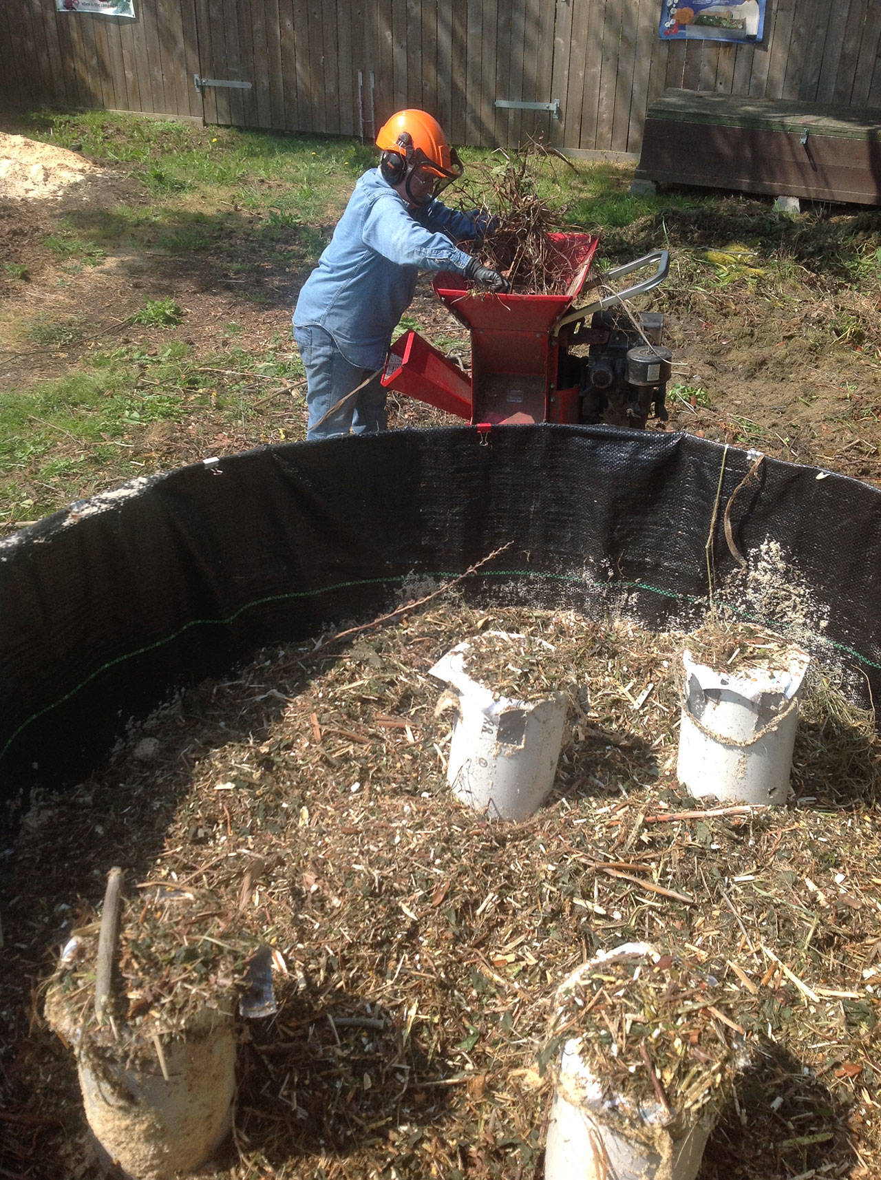 Al Cairo prepares shredded garden waste and fills the Johnson-Su composting bioreactor at Woodcock Garden. (Photo courtesy of Al Cairo)