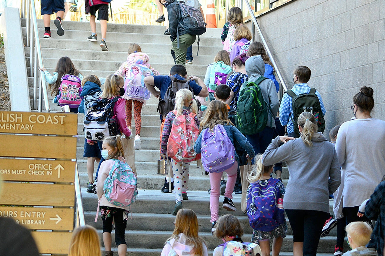 Jamie Haney helps her fourth-grader Elise prepare for the first day of school Tuesday morning at Salish Coast Elementary in Port Townsend. The school has 408 students enrolled in kindergarten through fifth grade; 21 were absent Tuesday, principal Lisa Condran noted. "We are very successfully running outdoor breakfast and lunch to keep our students safe, so we are excited about that," she added. (Diane Urbani de la Paz/Peninsula Daily News)
